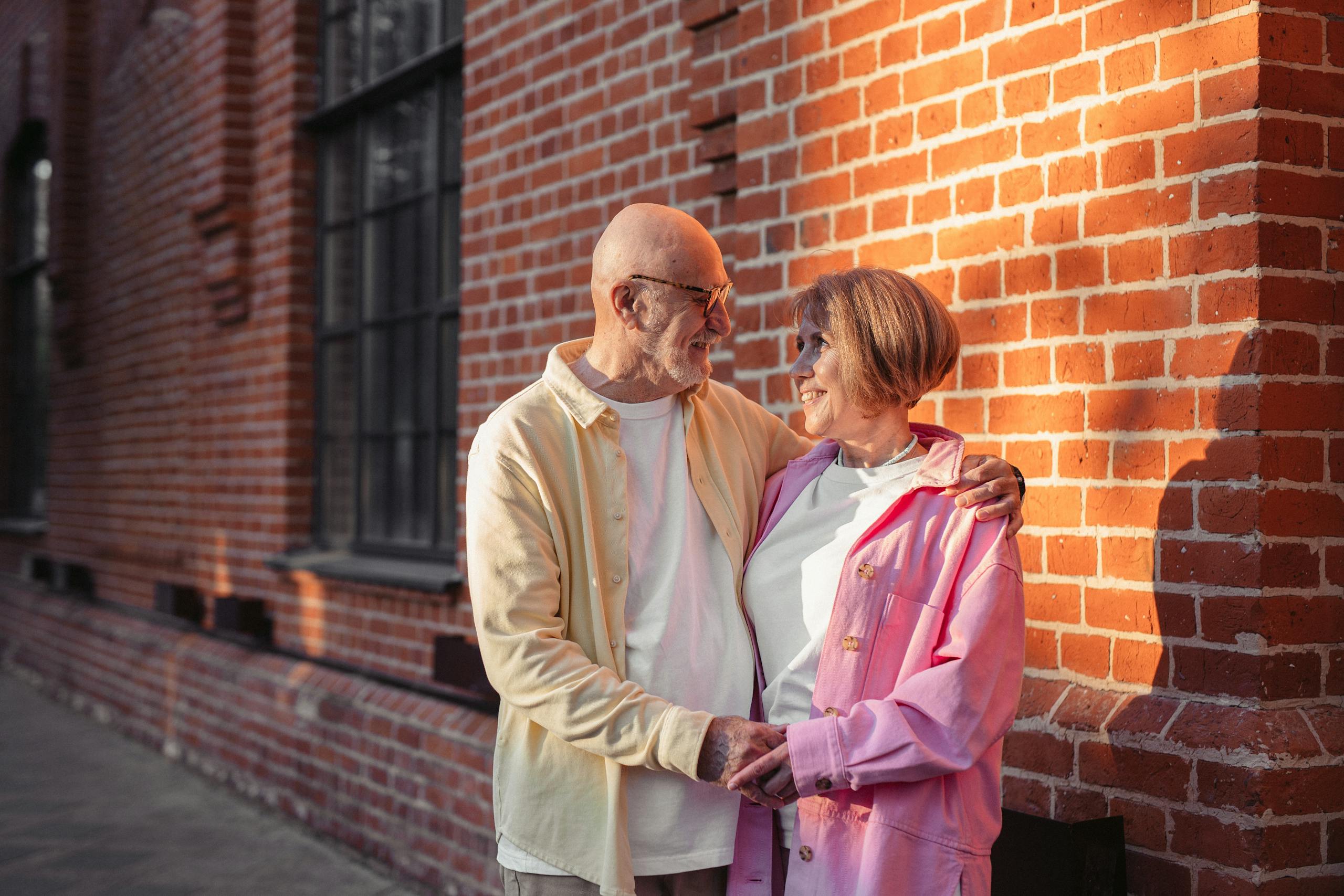 Man in Cream Dress Shirt Standing Beside Woman in Pink Coat